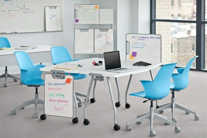 Verb tables with 4 blue node chairs and whiteboards. 
